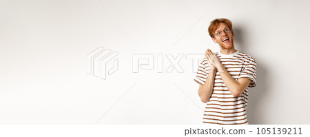 Happy redhead man clap hands and looking satisfied at upper right corner, getting ready for something, standing over white background 105139211