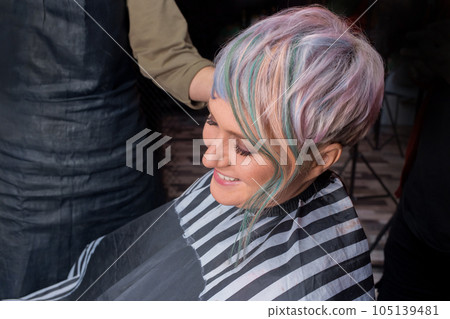 Smiling satisfied adult woman European barbershop customer with stylish, fashion creative color bob hair coloring Smiling satisfied adult woman European barbershop customer with stylish, fashion creative color bob hair coloring 105139481