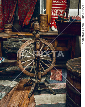 Living room with antique furniture and outdated utensils. Rural life of Russian peasants. Spinning Living room with antique furniture and outdated utensils. Rural life of Russian peasants. Spinning 105139599