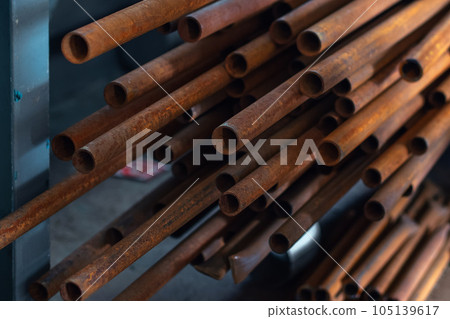 Round metal pipes of small diameter lie in stack. Front view. Pipes for water supply or gasification Round metal pipes of small diameter lie in stack. Front view. Pipes for water supply or gasification 105139617