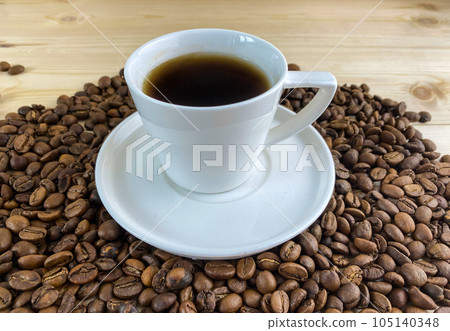 Coffee in a cup with a saucer, coffee grains. Coffee in a cup with a saucer, coffee grains. 105140348