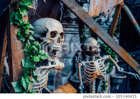 Outdoor Decor for Halloween. skeletons climbing out of the different wooden rubble. Halloween scenery. Terrible holiday photo zone on location for event. Traditions and decorations. Selective focus Outdoor Decor for Halloween. skeletons climbing out of the different wooden rubble. Halloween scenery. Terrible holiday photo zone on location for event. Traditions and decorations. Selective focus 105140435