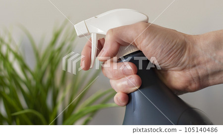 Hand with a spray bottle for flowers 105140486
