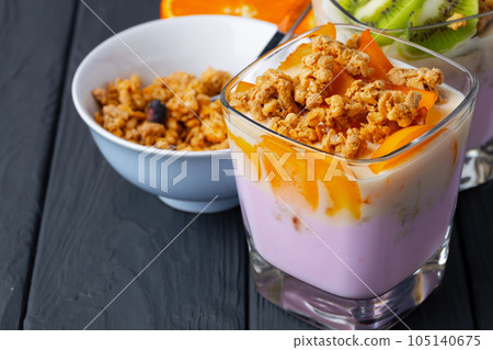Berry youghurt with granola and fruits in a glass Berry youghurt with granola and fruits in a glass 105140675
