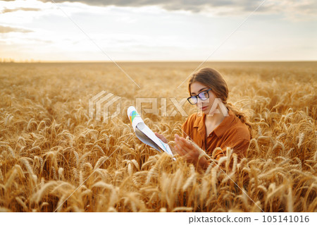 Farmer- woman on wheat field with tablet in his hands. Smart farm. Agriculture, gardening concept. 105141016