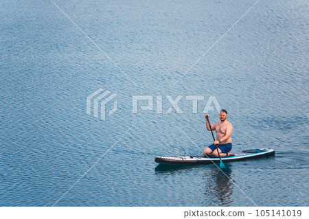 man on paddleboard in the middle of the lake 105141019
