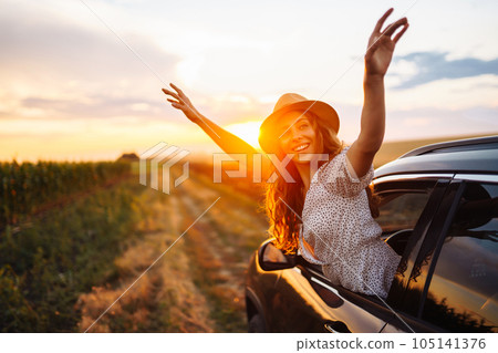 Relaxed happy woman on summer road trip travel vacation leaning out car window. Lifestyle. Relaxed happy woman on summer road trip travel vacation leaning out car window. Lifestyle. 105141376