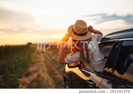Relaxed happy woman on summer road trip travel vacation leaning out car window. Lifestyle. 105141379