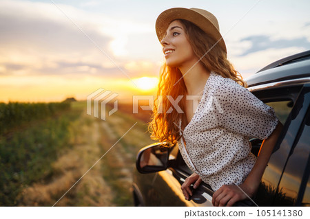 Relaxed happy woman on summer road trip travel vacation leaning out car window. Lifestyle. 105141380