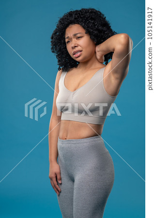 Curly-haired woman suffering from neck pain Curly-haired woman suffering from neck pain 105141917