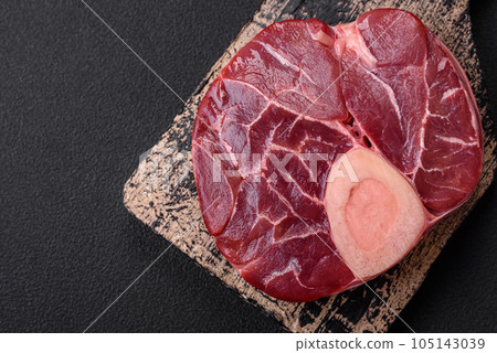 Fresh raw beef steak with bone or ossobuco with salt, spices and herbs 105143039