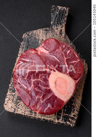Fresh raw beef steak with bone or ossobuco with salt, spices and herbs 105143040