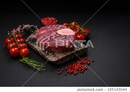 Fresh raw beef steak with bone or ossobuco with salt, spices and herbs 105143044