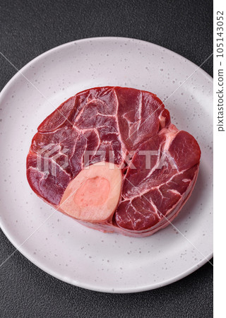 Fresh raw beef steak with bone or ossobuco with salt, spices and herbs 105143052