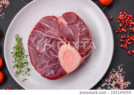 Fresh raw beef steak with bone or ossobuco with salt, spices and herbs 105143059