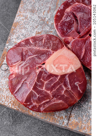 Fresh raw beef steak with bone or ossobuco with salt, spices and herbs 105143062