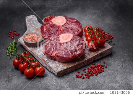 Fresh raw beef steak with bone or ossobuco with salt, spices and herbs Fresh raw beef steak with bone or ossobuco with salt, spices and herbs 105143066