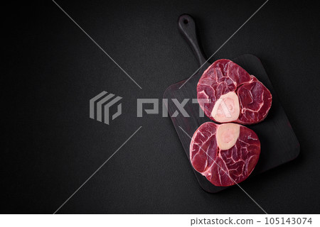 Fresh raw beef steak with bone or ossobuco with salt, spices and herbs Fresh raw beef steak with bone or ossobuco with salt, spices and herbs 105143074