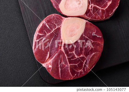 Fresh raw beef steak with bone or ossobuco with salt, spices and herbs Fresh raw beef steak with bone or ossobuco with salt, spices and herbs 105143077