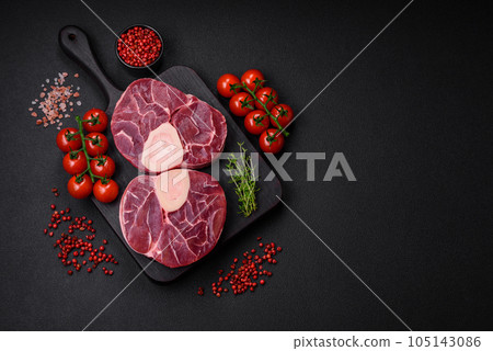Fresh raw beef steak with bone or ossobuco with salt, spices and herbs Fresh raw beef steak with bone or ossobuco with salt, spices and herbs 105143086