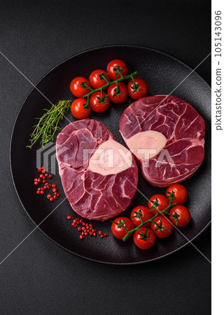 Fresh raw beef steak with bone or ossobuco with salt, spices and herbs Fresh raw beef steak with bone or ossobuco with salt, spices and herbs 105143096