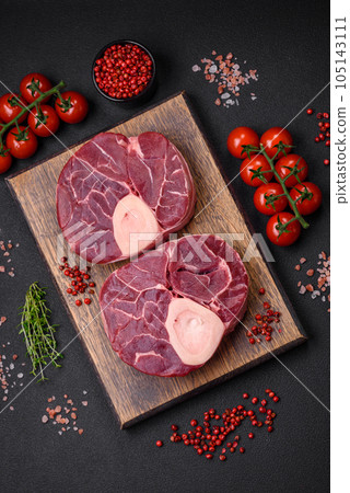 Fresh raw beef steak with bone or ossobuco with salt, spices and herbs Fresh raw beef steak with bone or ossobuco with salt, spices and herbs 105143111