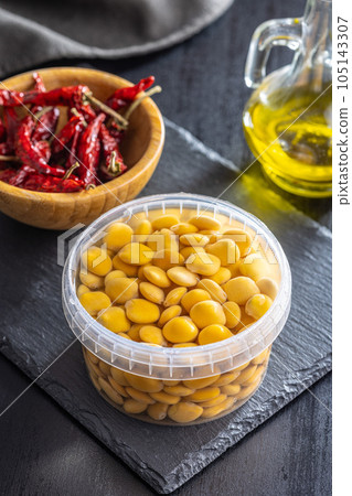 Lupini beans in brine. Pickled lupin in bowl on black table. Lupini beans in brine. Pickled lupin in bowl on black table. 105143307