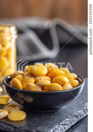 Lupini beans in brine. Pickled lupin in bowl on black table. Lupini beans in brine. Pickled lupin in bowl on black table. 105143309
