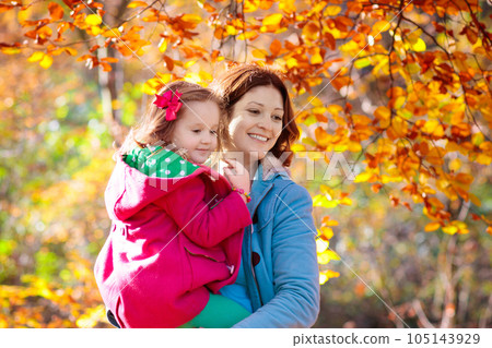Mother and kid in autumn. Fall outdoor family fun. Mother and kid in autumn. Fall outdoor family fun. 105143929