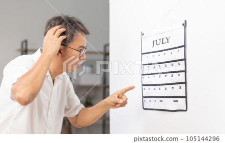 Confused Asian Senior Man With Dementia Looking At Wall Calendar 105144296
