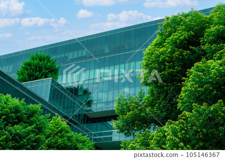 Eco-friendly building in the modern city. Sustainable glass office building with trees for reducing heat and carbon dioxide. Office building with green environment. Corporate building reduce CO2. 105146367