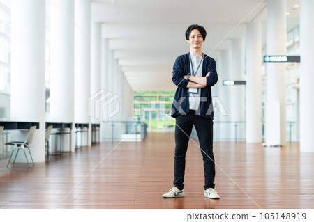 Young man folding his arms in an office corridor 105148919