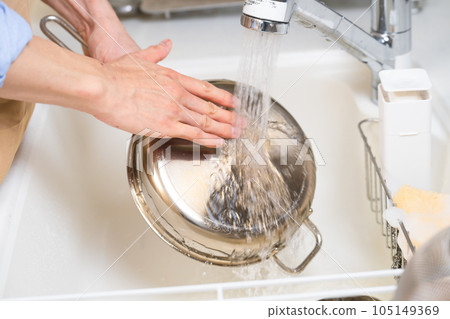Young man washing dishes Lifestyle image 105149369