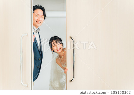 Guests at the venue, peeking at friends from the door, bride and groom looking out from the door 105150362