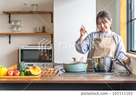 Asian woman cooking in the kitchen (curry stew) Asian woman cooking in the kitchen (curry stew) 105151165