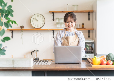 亞洲女性在家庭廚房使用筆記本電腦尋找食譜和營養 亞洲女性在家庭廚房使用筆記本電腦尋找食譜和營養 105151440