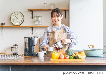 早上穿著圍裙在廚房裡煮咖啡的亞洲女人 早上穿著圍裙在廚房裡煮咖啡的亞洲女人 105151441