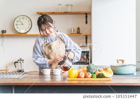 早上穿著圍裙在廚房裡煮咖啡的亞洲女人 105151447
