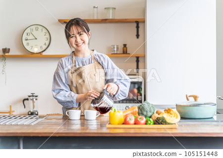 早上穿著圍裙在廚房裡煮咖啡的亞洲女人 105151448