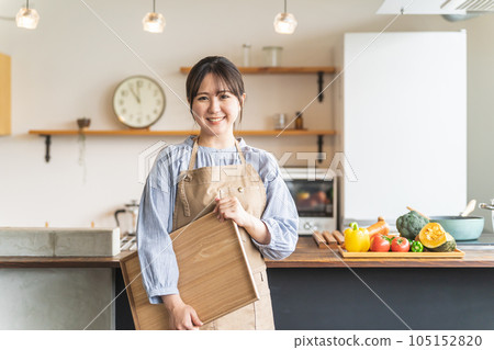 一位亞洲女性,她是管家、家政代理、在廚房圍裙工作的烹飪代理員工 一位亞洲女性,她是管家、家政代理、在廚房圍裙工作的烹飪代理員工 105152820
