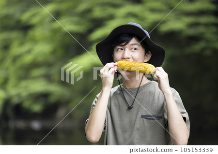 Young man eating grilled corn BBQ image Young man eating grilled corn BBQ image 105153339