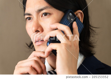 Young businessman talking on smartphone Young businessman talking on smartphone 105153352