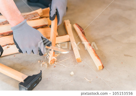 一個男人砍柴為篝火製作羽毛棒 105153556