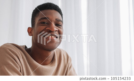 Video call. Virtual meeting. Positive attitude. Joyful optimistic cheerful young man in good mood with happy toothy smile at window copy space. 105154233