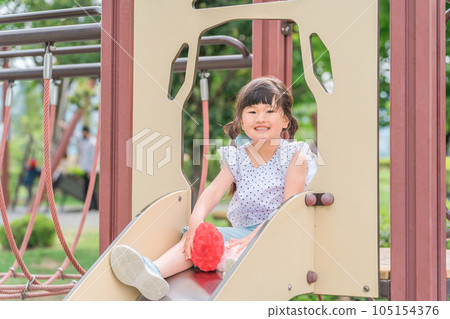 child playing on playground equipment in the park 105154376