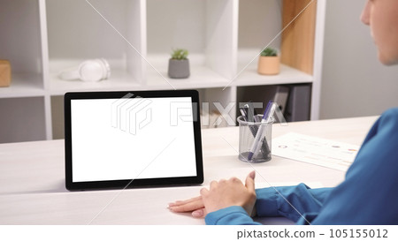 Internet conference. Video interview. Online communication. Remote work. Business woman at office desk with digital tablet with empty space white mockup screen at workplace. 105155012