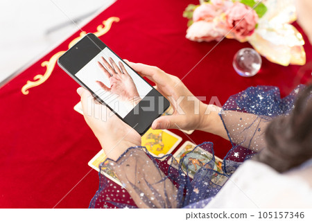 手持智能手機進行在線手相診斷和手相鑑定的算命先生 105157346