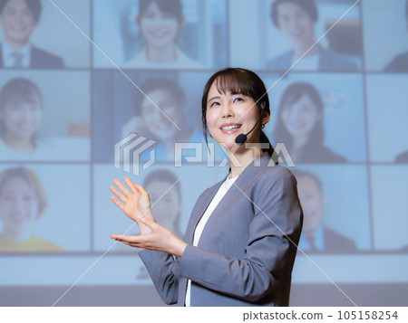 一位女講師在大廳裡給通過可視電話與觀眾連接的人講課 105158254