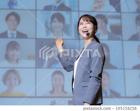 一位女講師在大廳裡給通過可視電話與觀眾連接的人講課 一位女講師在大廳裡給通過可視電話與觀眾連接的人講課 105158256