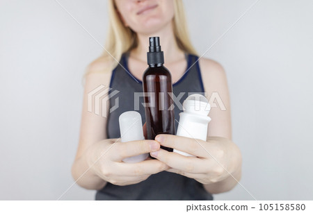 Girl holds in her hands three eco-friendly antiperspirants with natural ingredients. Refusal of antiperspirants containing toxic substances. Freedom from Aluminum chlorohydrate, alcohol, parabens 105158580